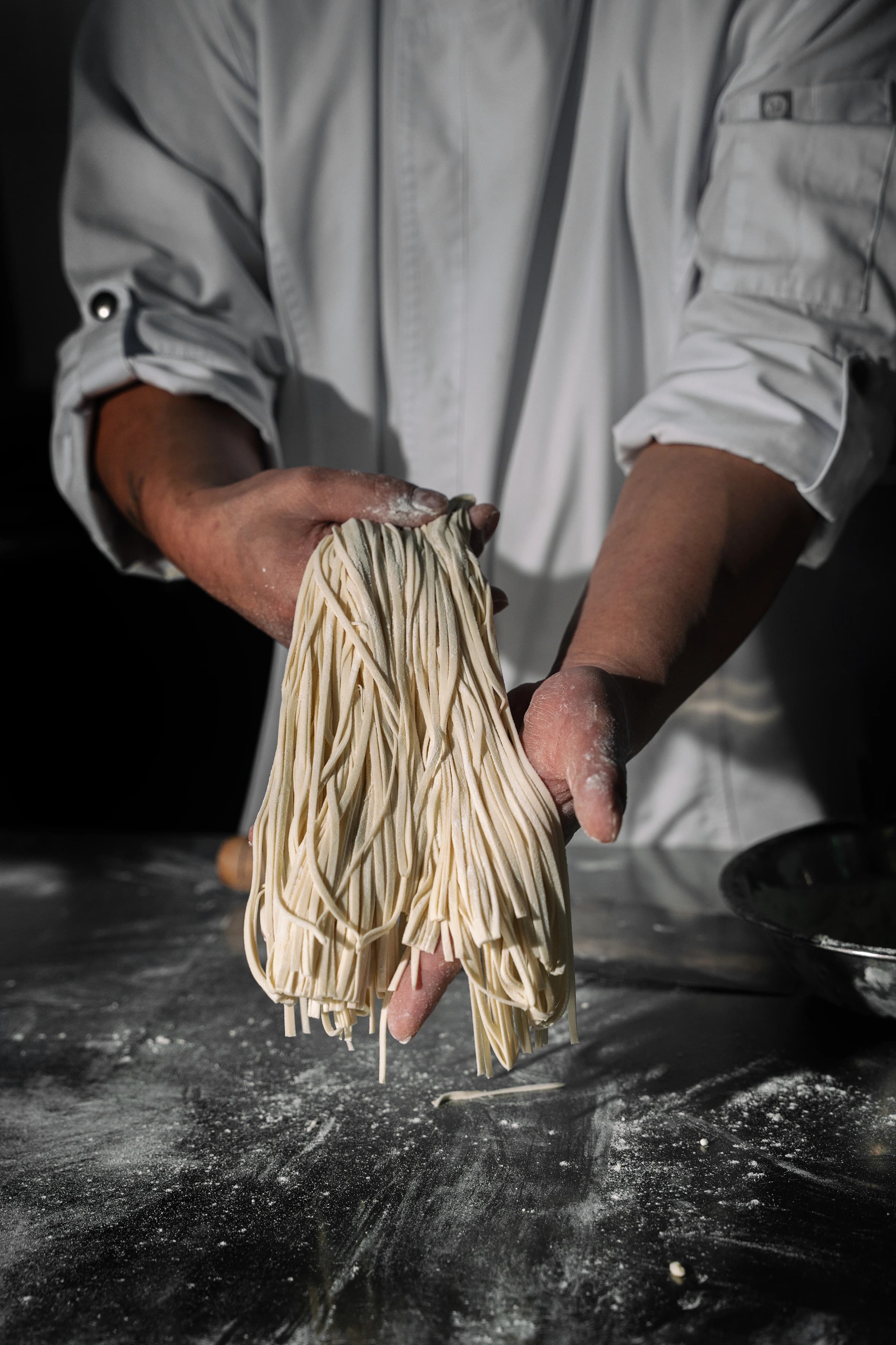 Noodles feitos à mão segurados pelo chef