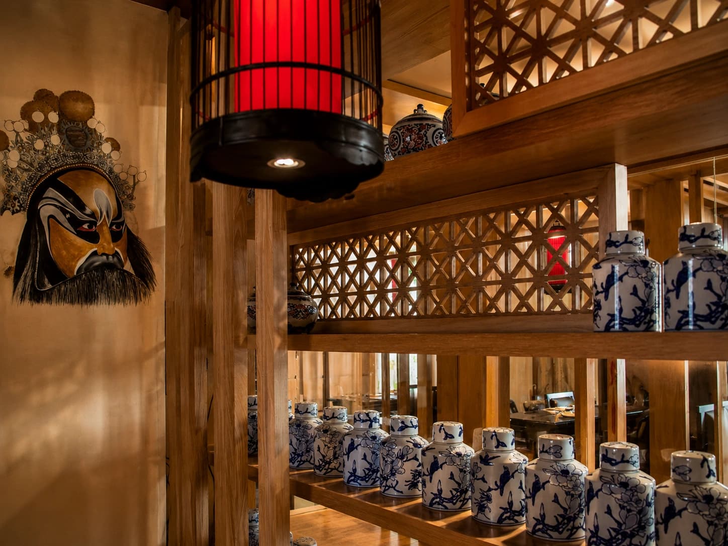 Interior do The Old House com lanterna vermelha e prateleiras de porcelana